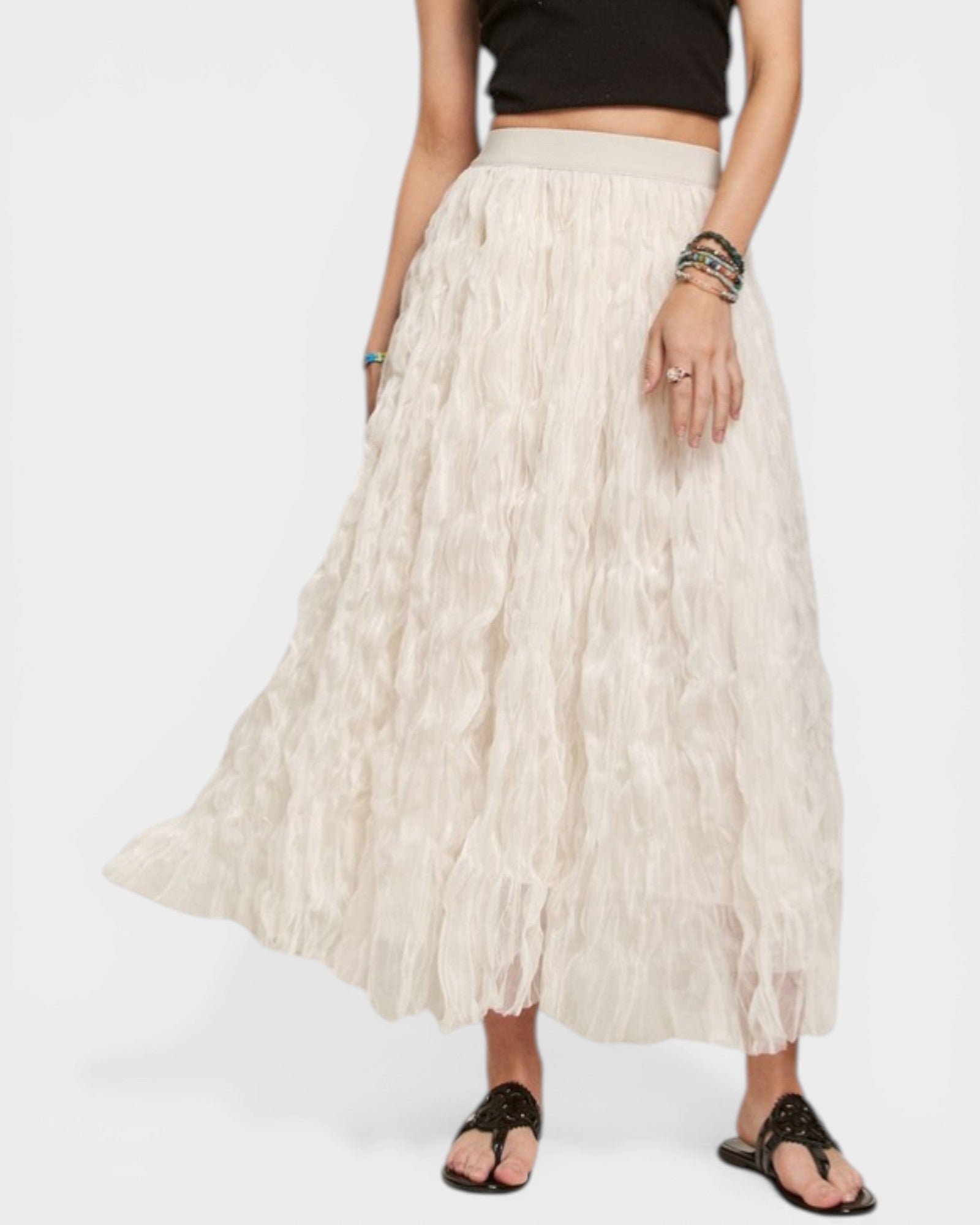 Person wearing a long beige skirt on a white background