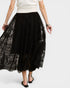 Person wearing a black lace skirt and white top on a white background