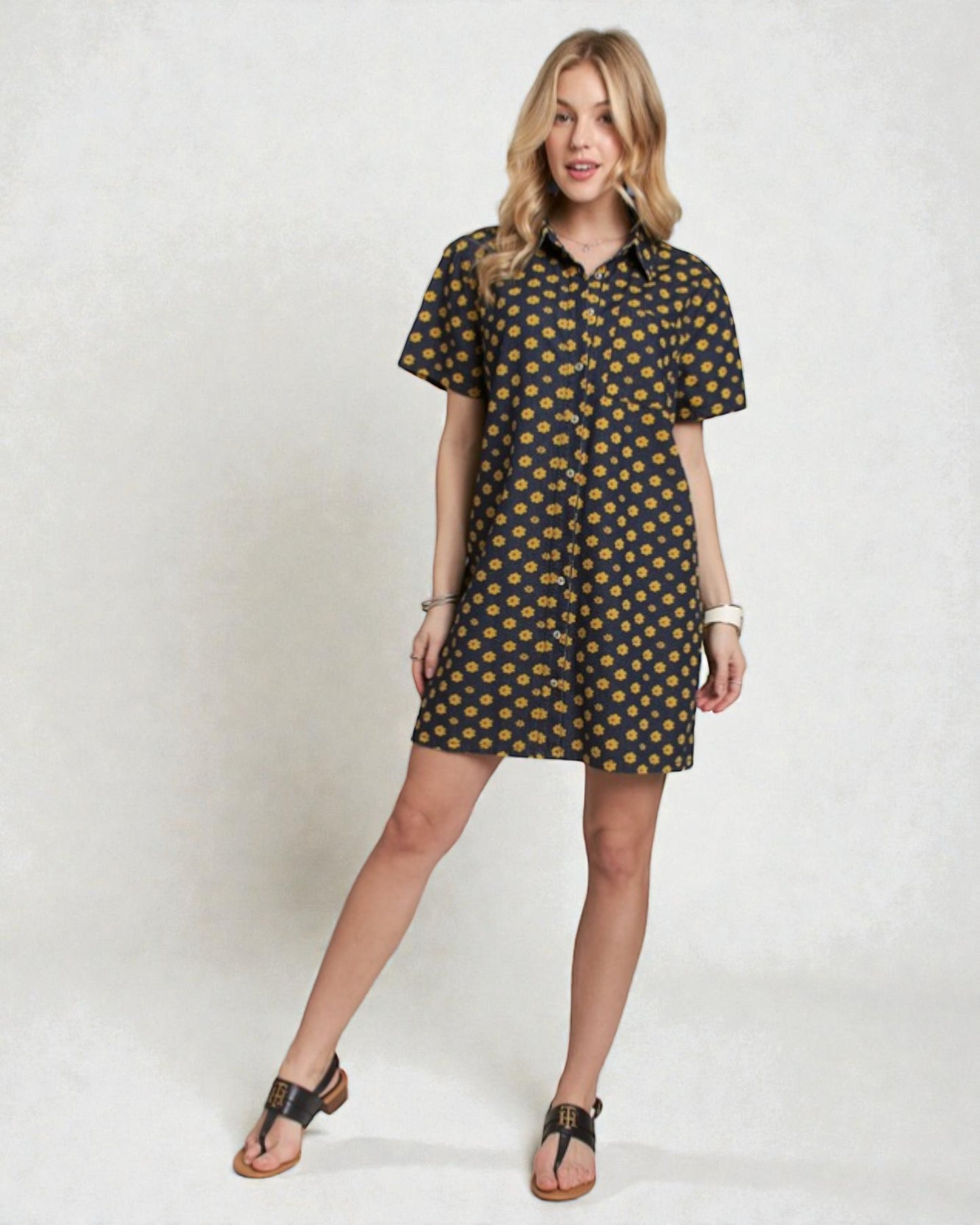 Woman wearing a black dress with yellow pattern on a white background