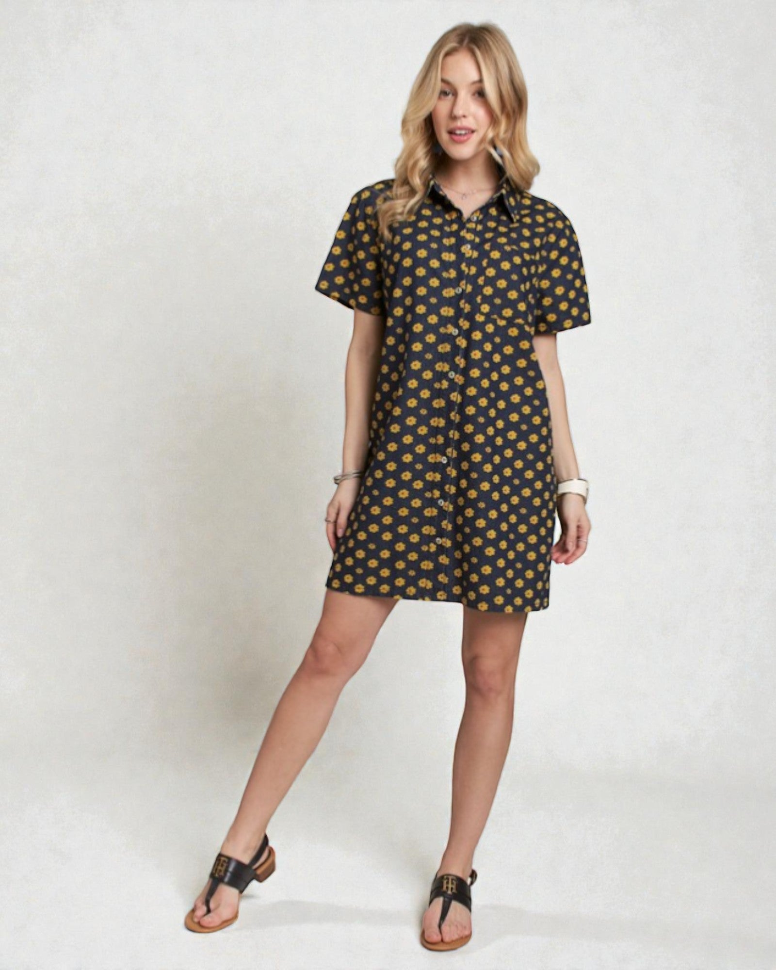 Woman wearing a black dress with yellow pattern on a white background