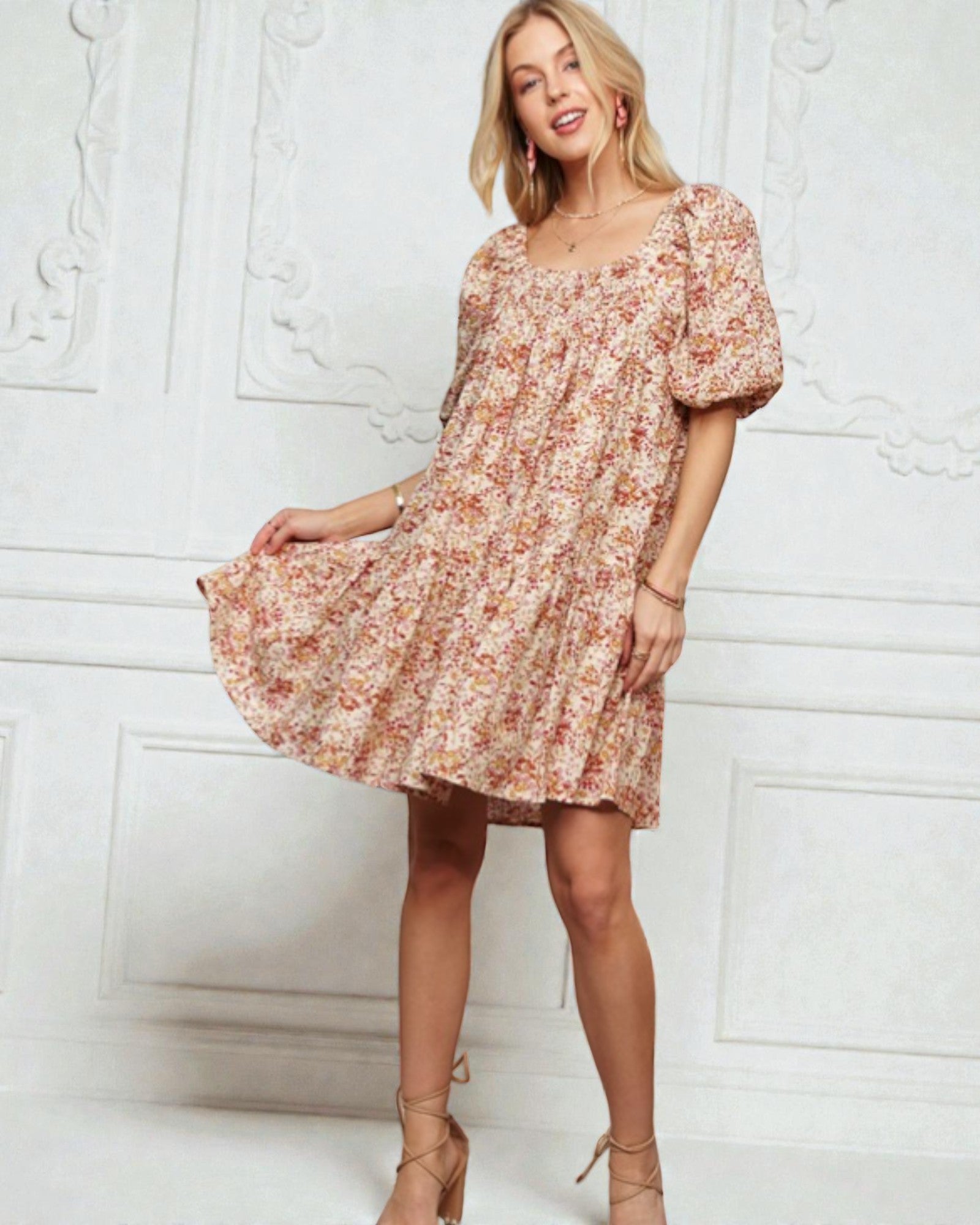 Woman wearing a floral dress against a white wall