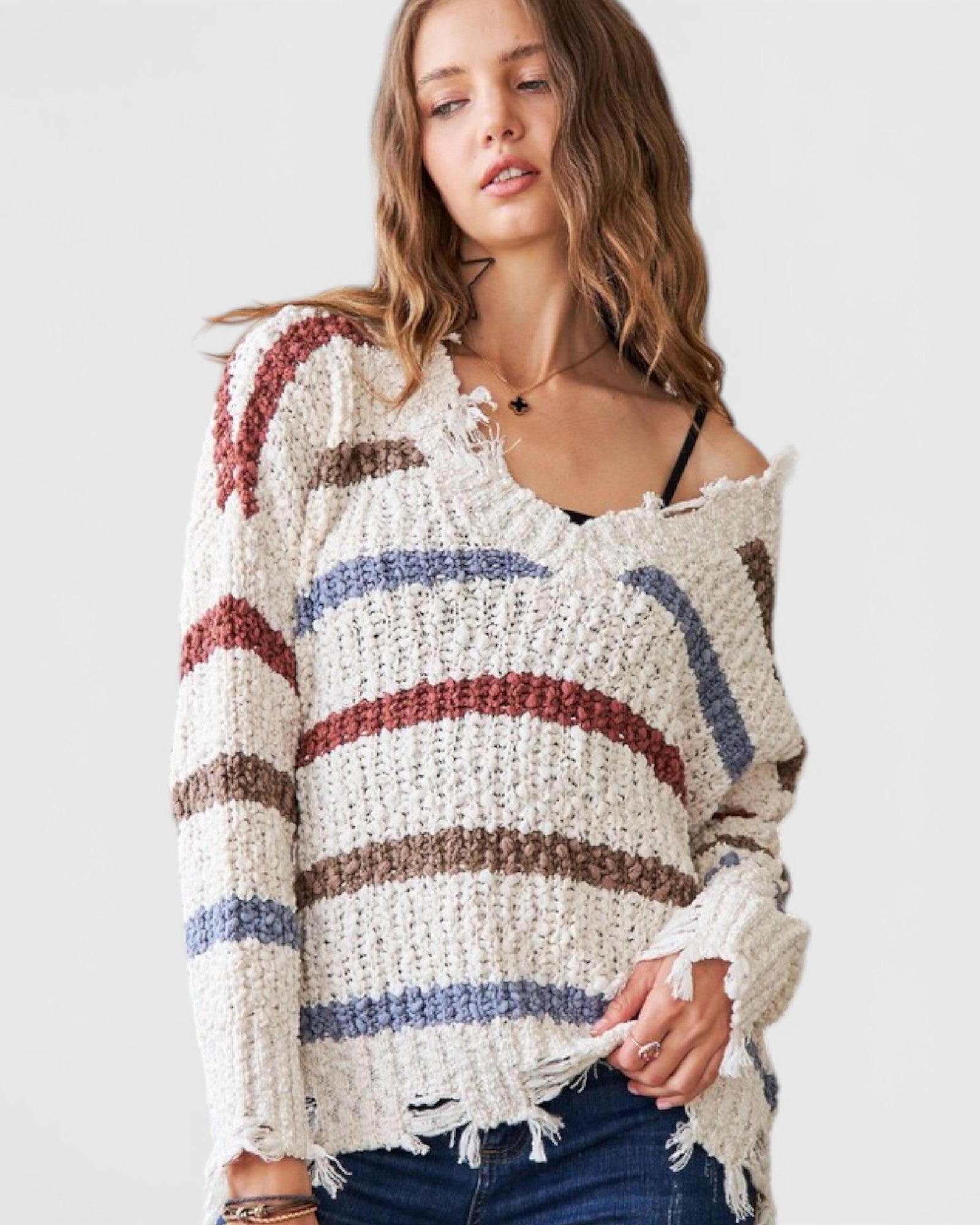 Woman wearing a colorful striped sweater against a plain background