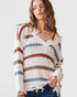 Woman wearing a colorful striped sweater against a plain background