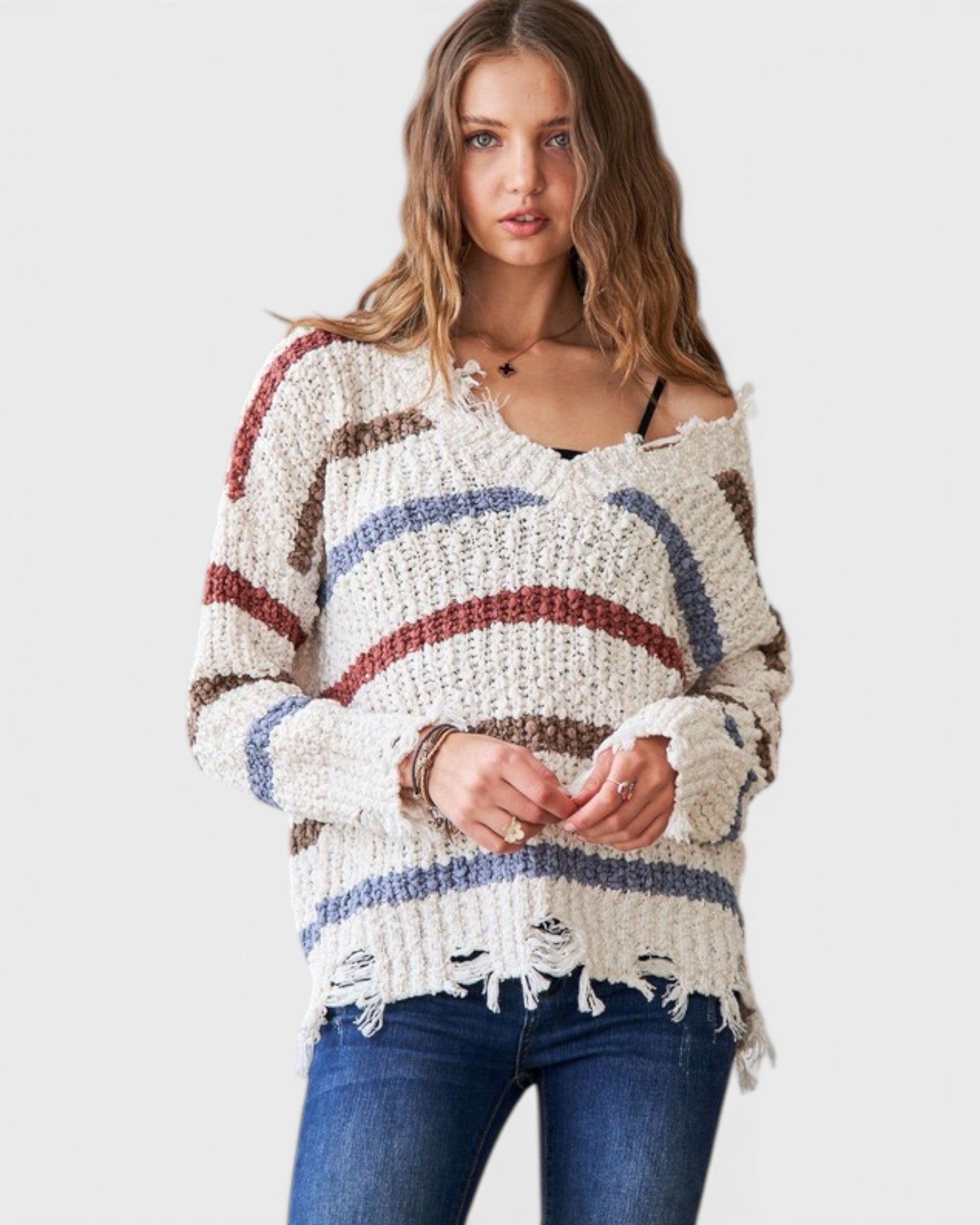 Woman wearing a colorful striped sweater with a plain background