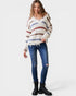Woman wearing a striped sweater and blue jeans on a white background