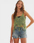 Woman wearing a green crochet top and denim shorts on a white background