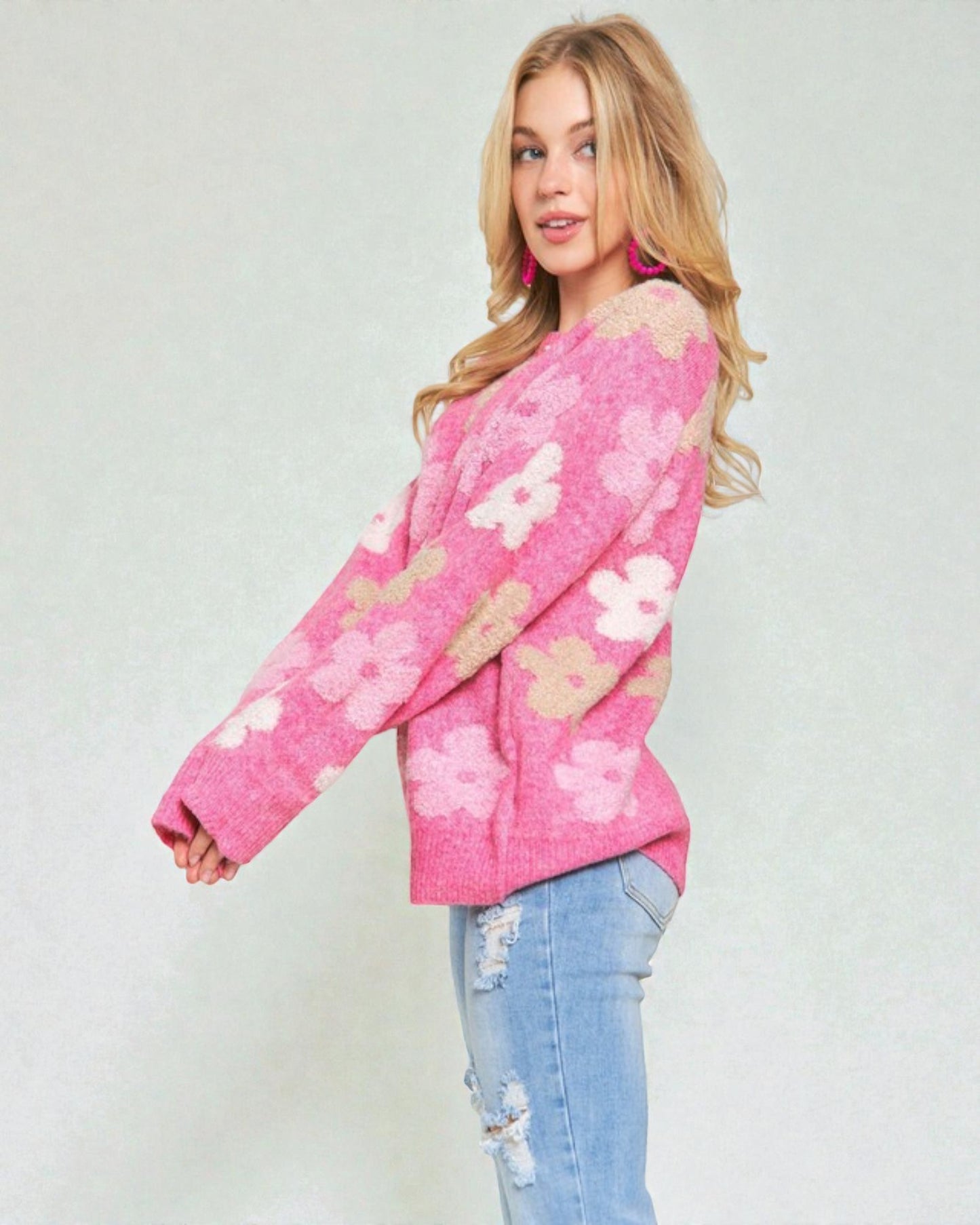 Woman wearing a pink floral sweater against a plain background