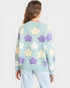 Light blue sweater with floral pattern worn by a person on a white background