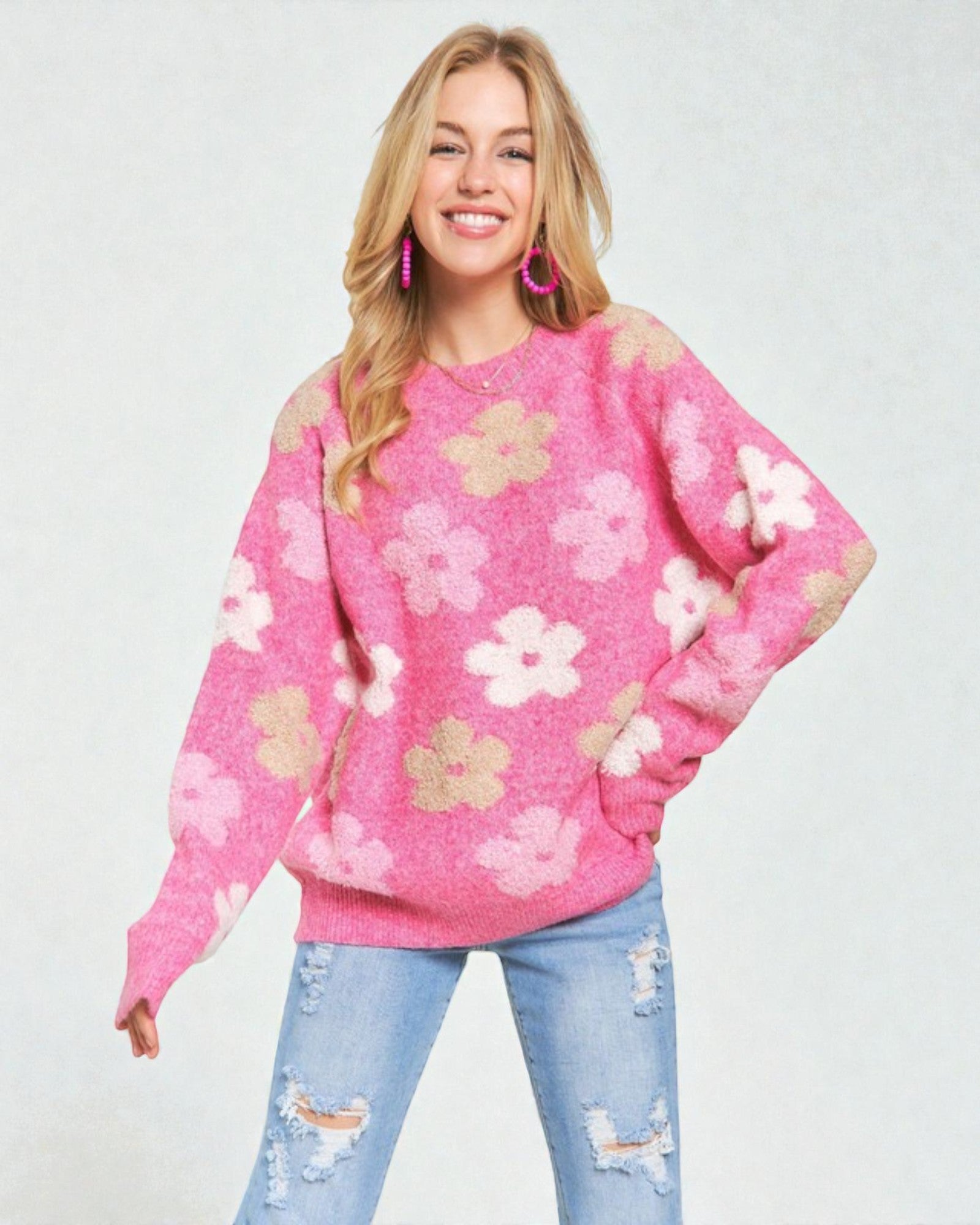 Woman wearing a pink floral sweater against a white background