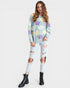 Woman wearing a floral sweater and ripped jeans on a white background