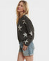 Woman wearing a dark gray sweater with star patterns on a white background