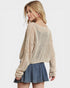 Woman wearing a beige knitted sweater and denim skirt on a white background
