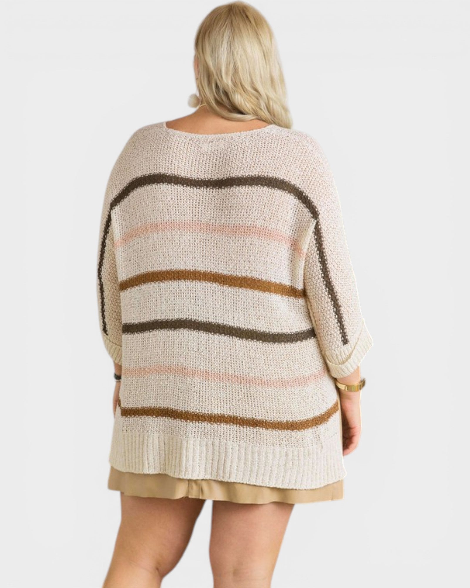 Woman wearing a striped sweater with a plain background