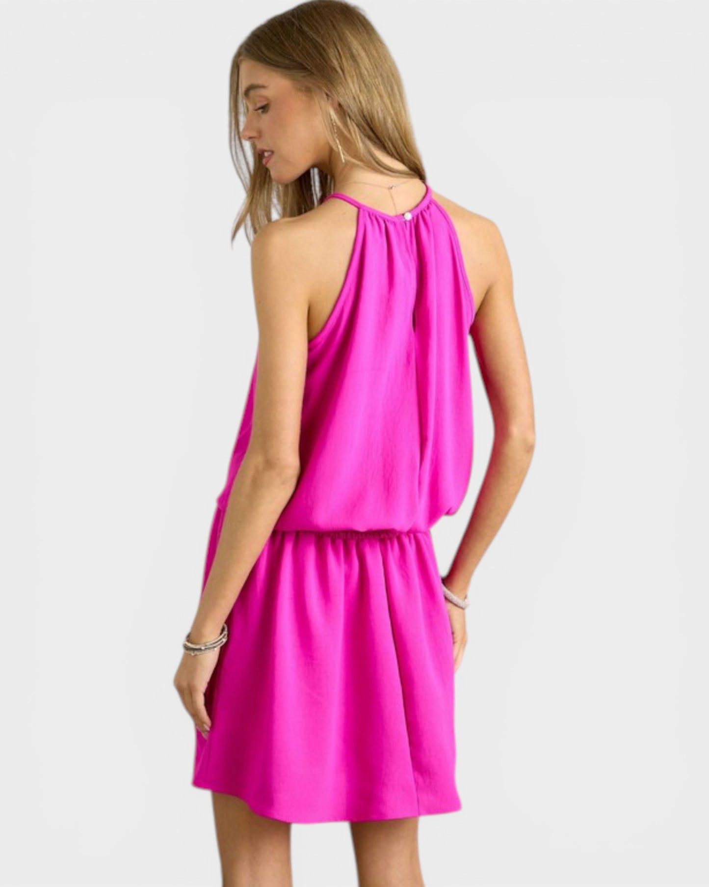 Woman wearing a bright pink dress on a white background