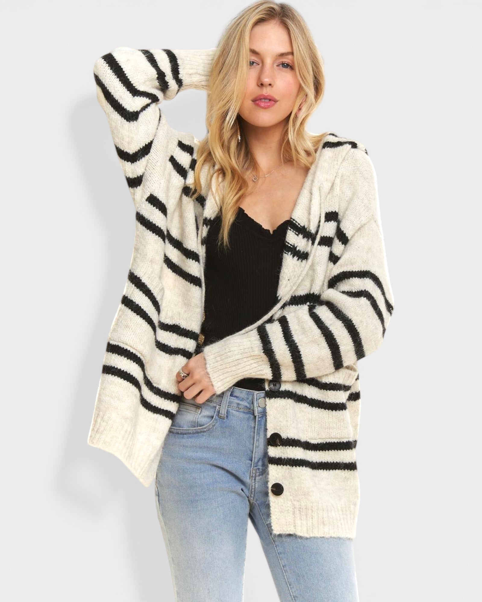 Woman wearing a black and white striped cardigan on a light gray background
