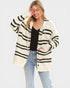 Woman wearing a black and white striped cardigan on a plain background
