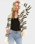 Woman wearing a black and white striped cardigan on a light gray background