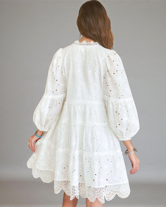 White lace dress worn by a person on a gray background