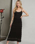 Woman wearing a black dress posing in a studio setting.