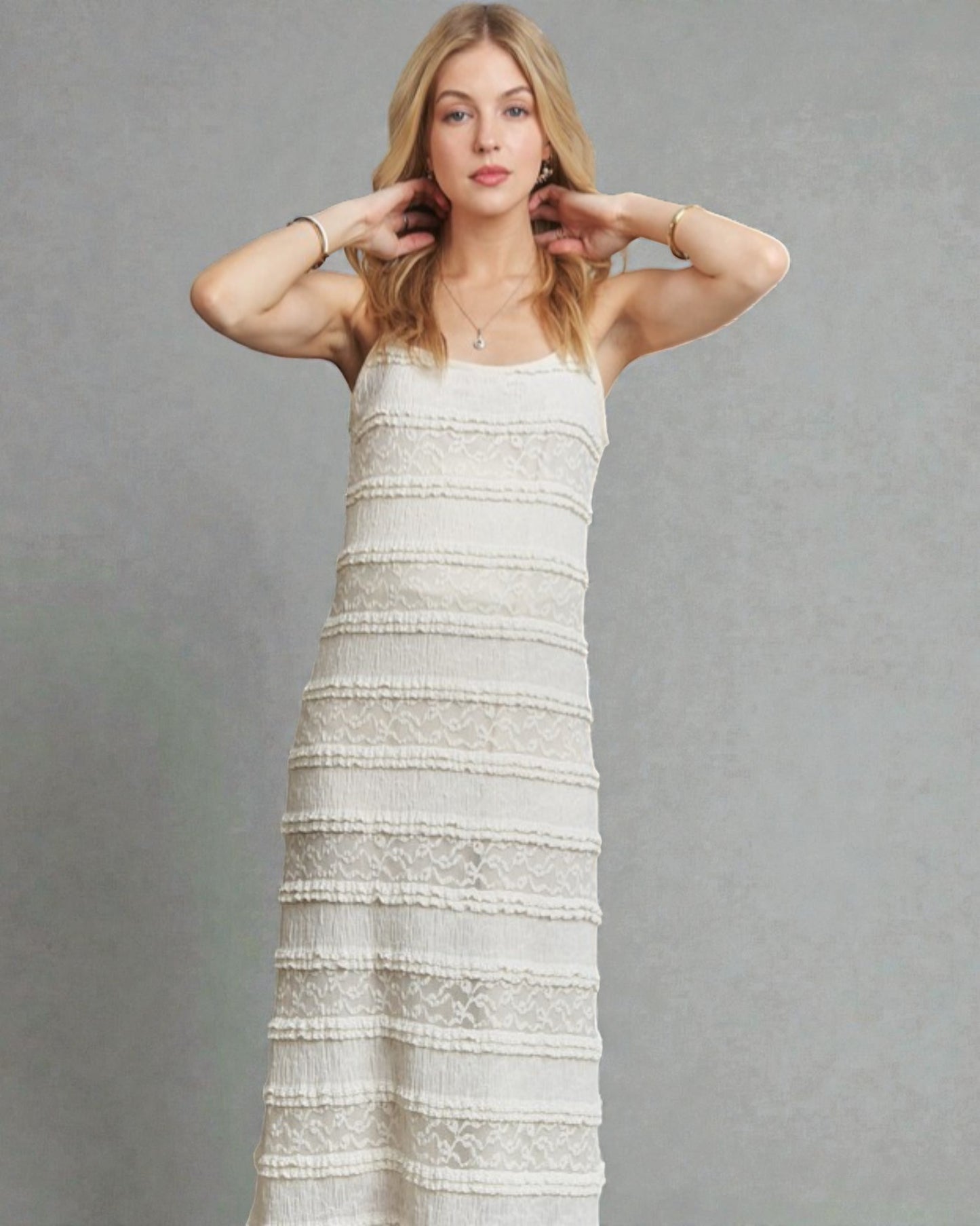 Woman wearing a white lace dress against a gray background