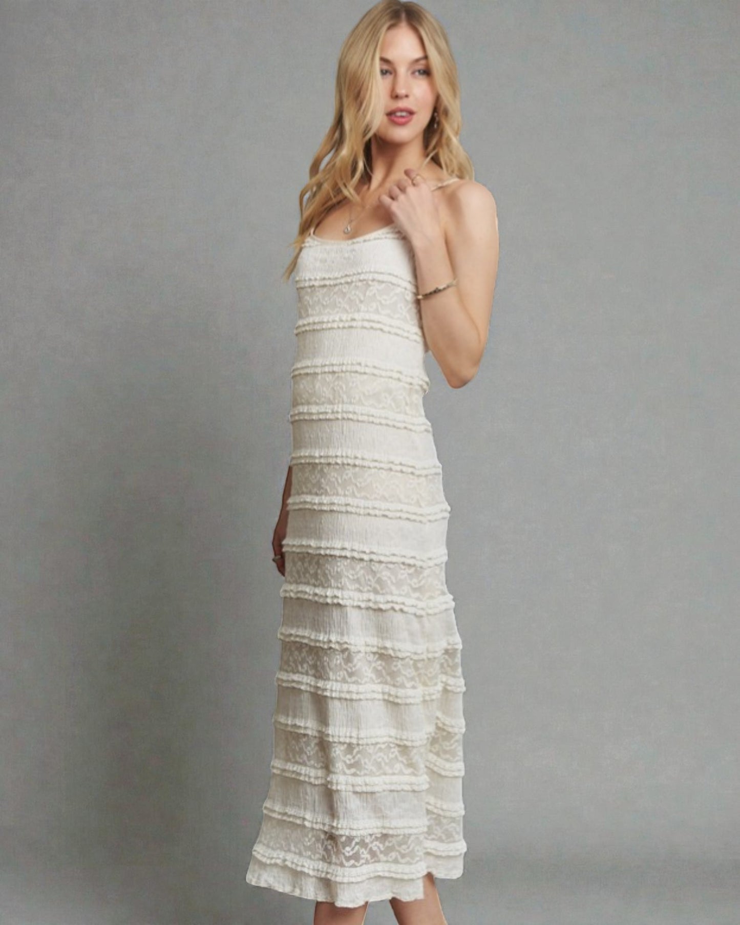 Woman wearing a white lace dress against a gray background