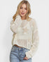 Woman wearing a cream-colored sweater with star patterns on a white background