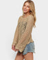 Woman wearing a beige crochet sweater and denim shorts on a white background