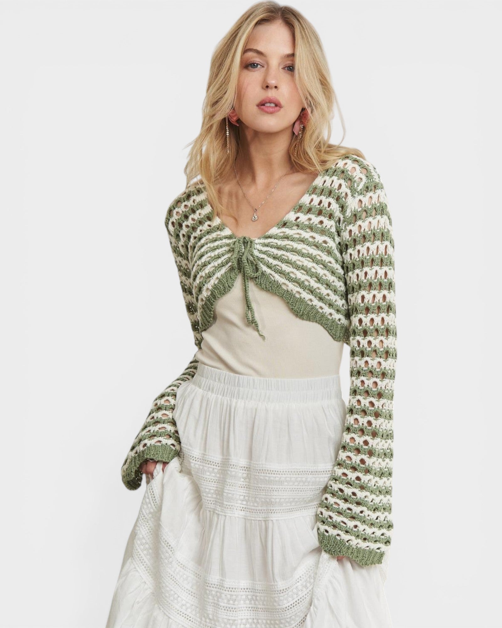 Woman wearing a green and white striped crochet cardigan on a white background