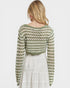 Person wearing a green and white patterned sweater on a light background