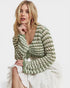 Woman wearing a green and white patterned shrug on a white background