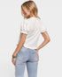 Woman wearing a white blouse and light blue jeans on a plain background