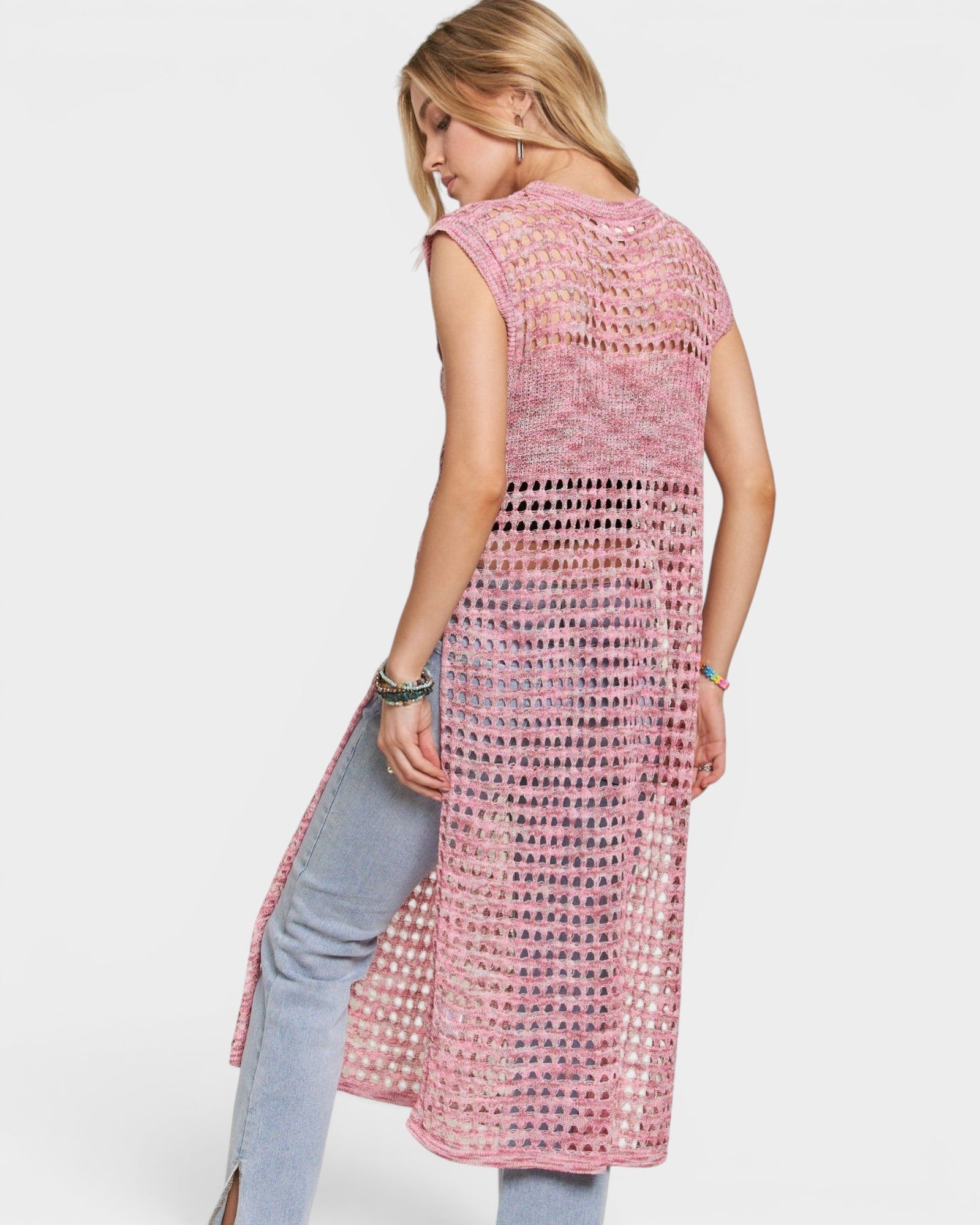 Woman wearing a pink crochet dress on a white background