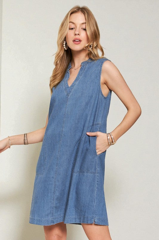 Woman wearing a blue denim dress against a plain background