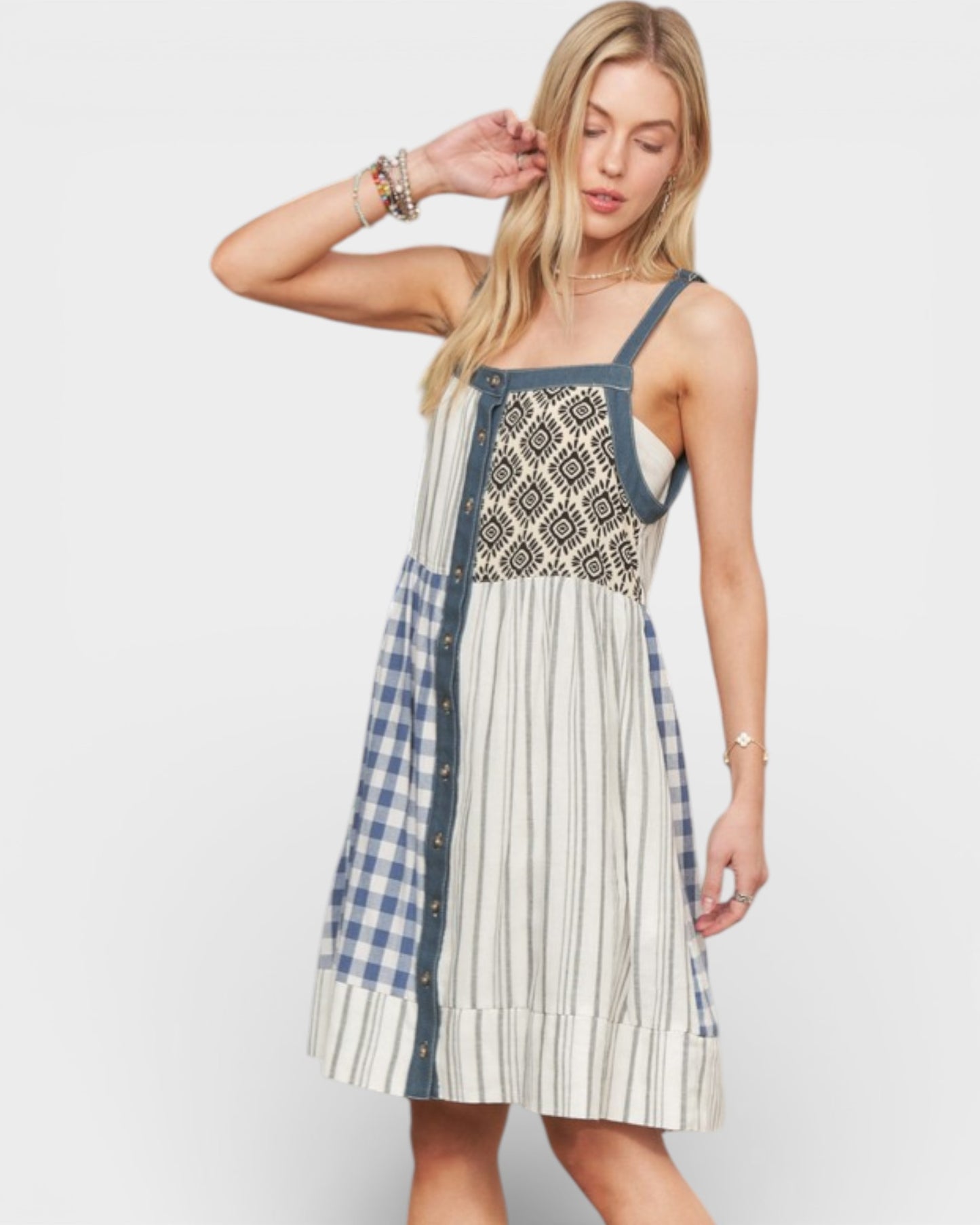 Woman wearing a dress with plaid and patterned design on a white background