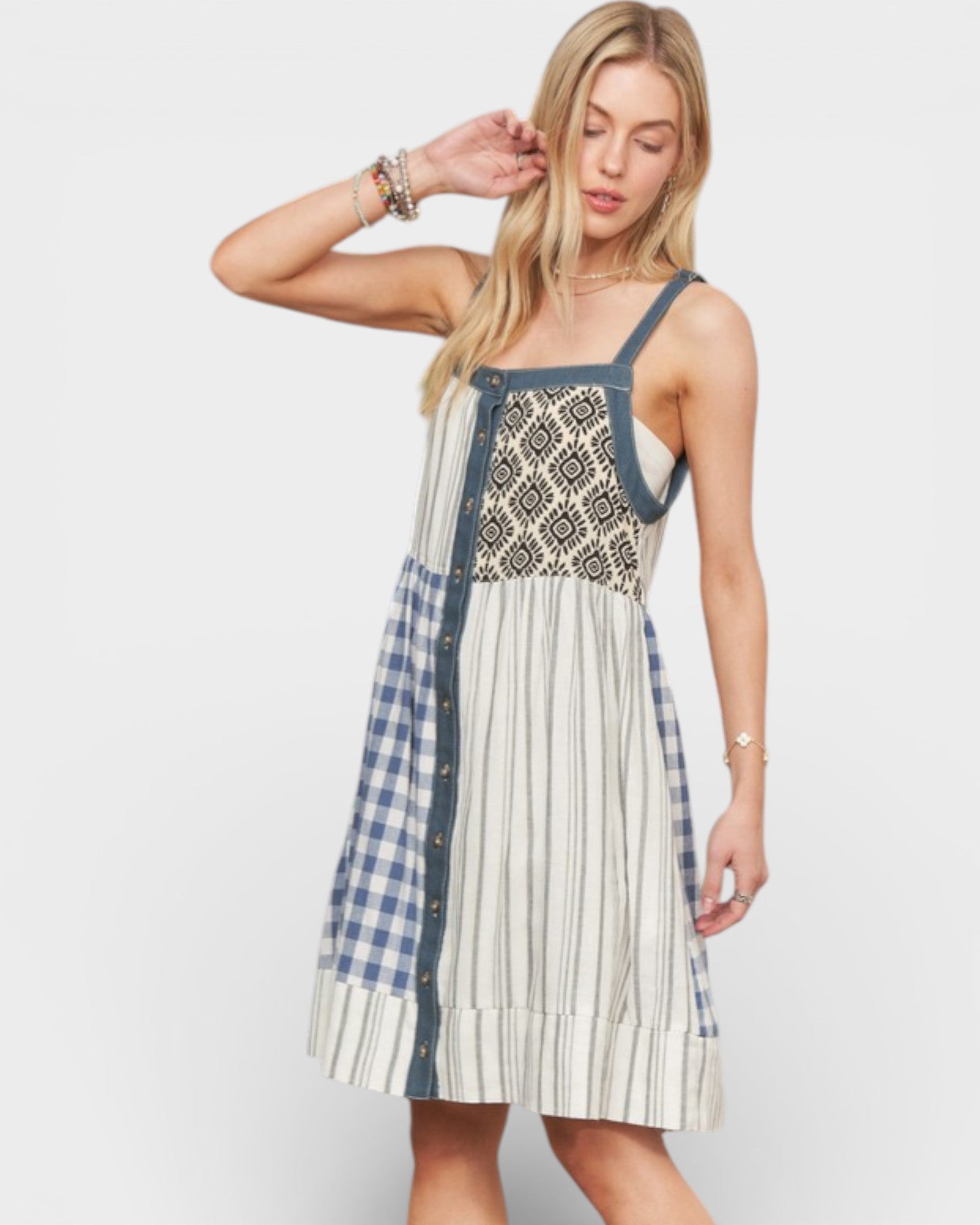 Woman wearing a dress with plaid and patterned design on a white background