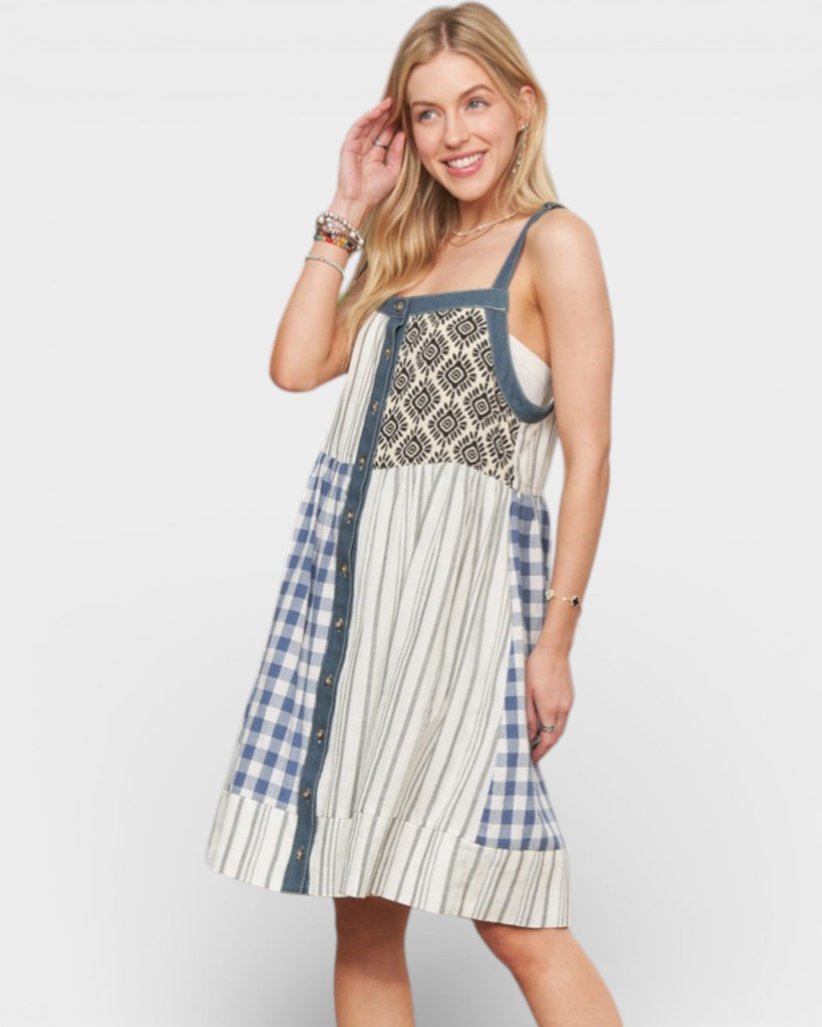 Woman wearing a patchwork dress with plaid and striped patterns on a white background