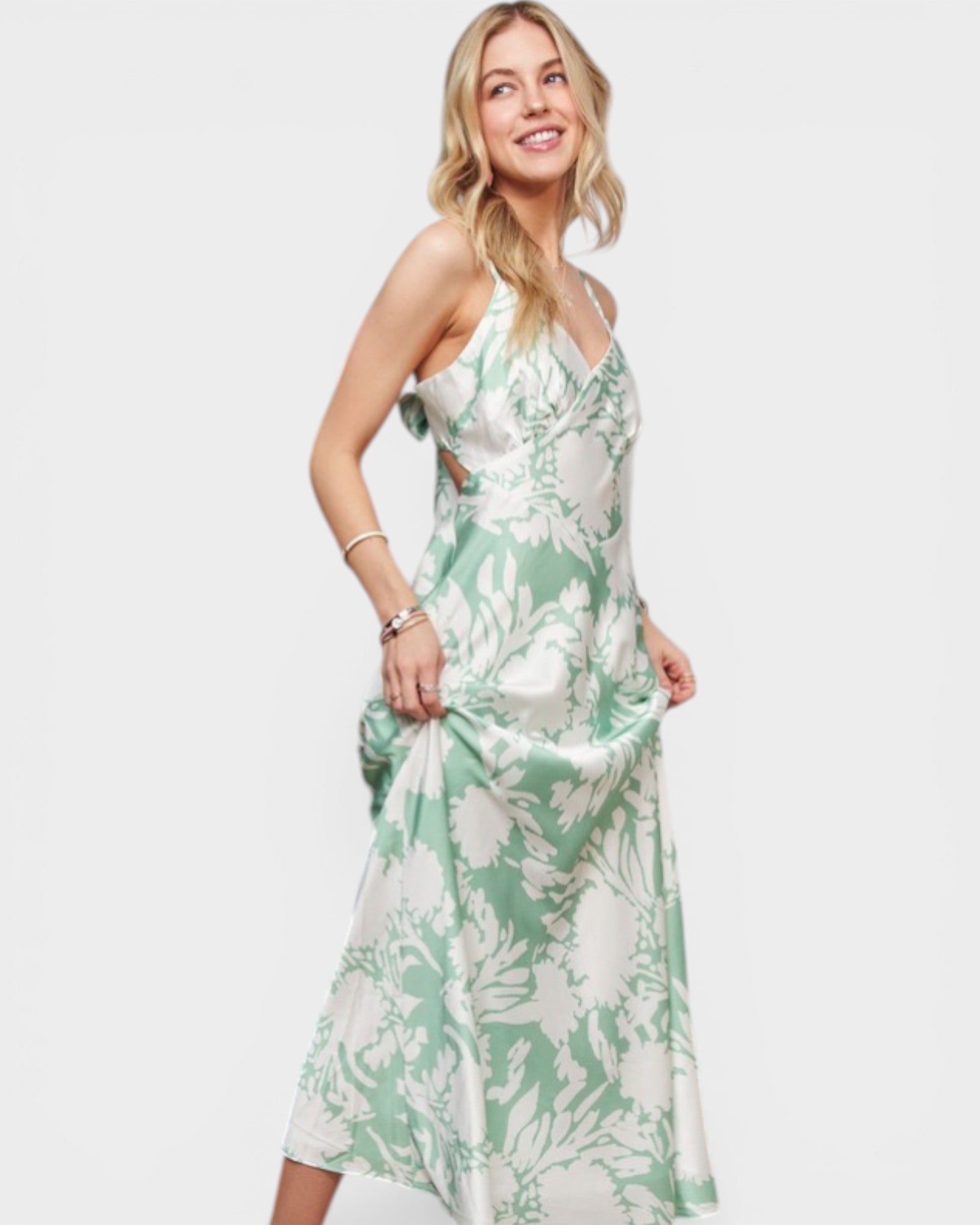Woman wearing a green and white floral dress on a white background