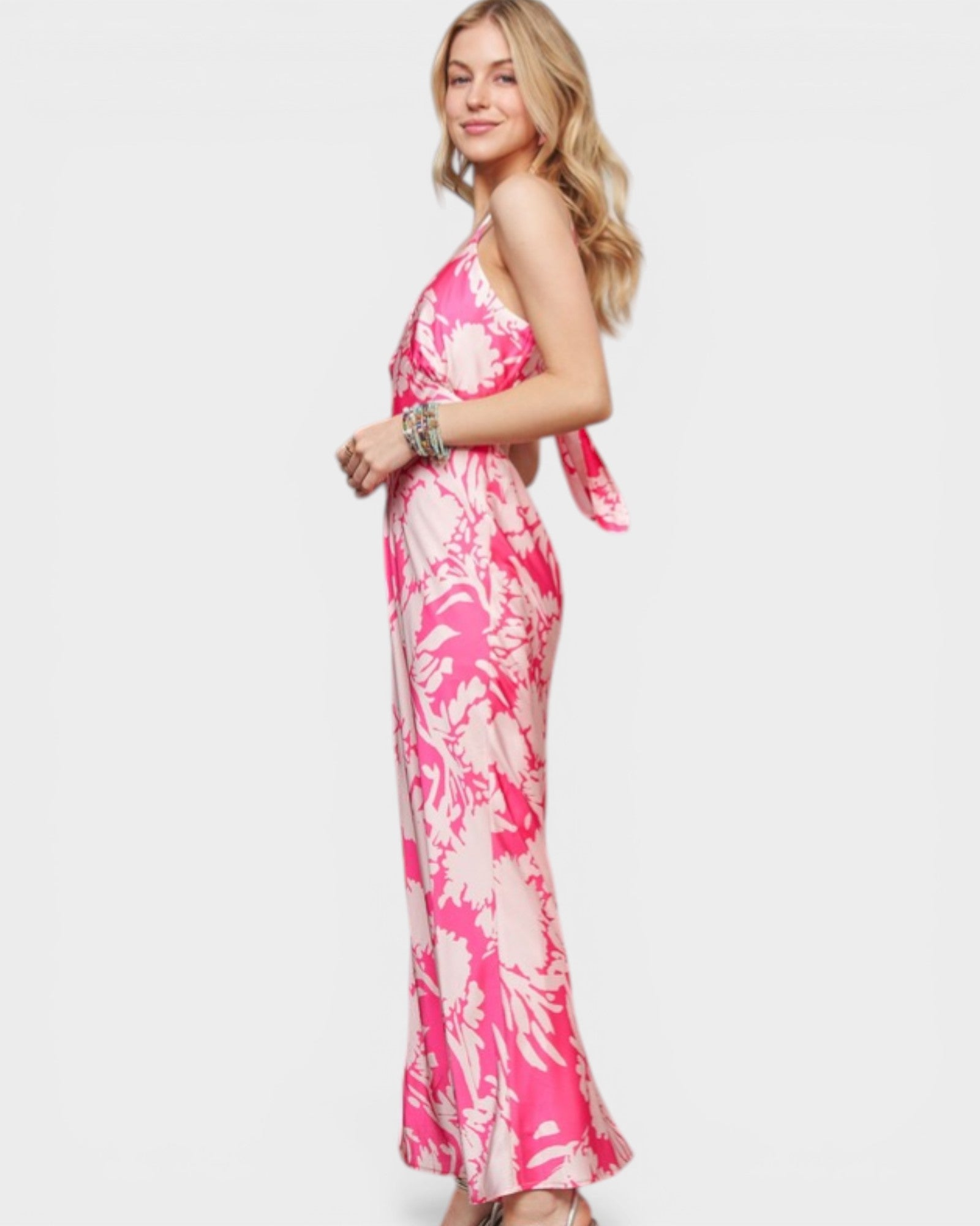 Woman wearing a pink and white tie-dye dress on a plain background