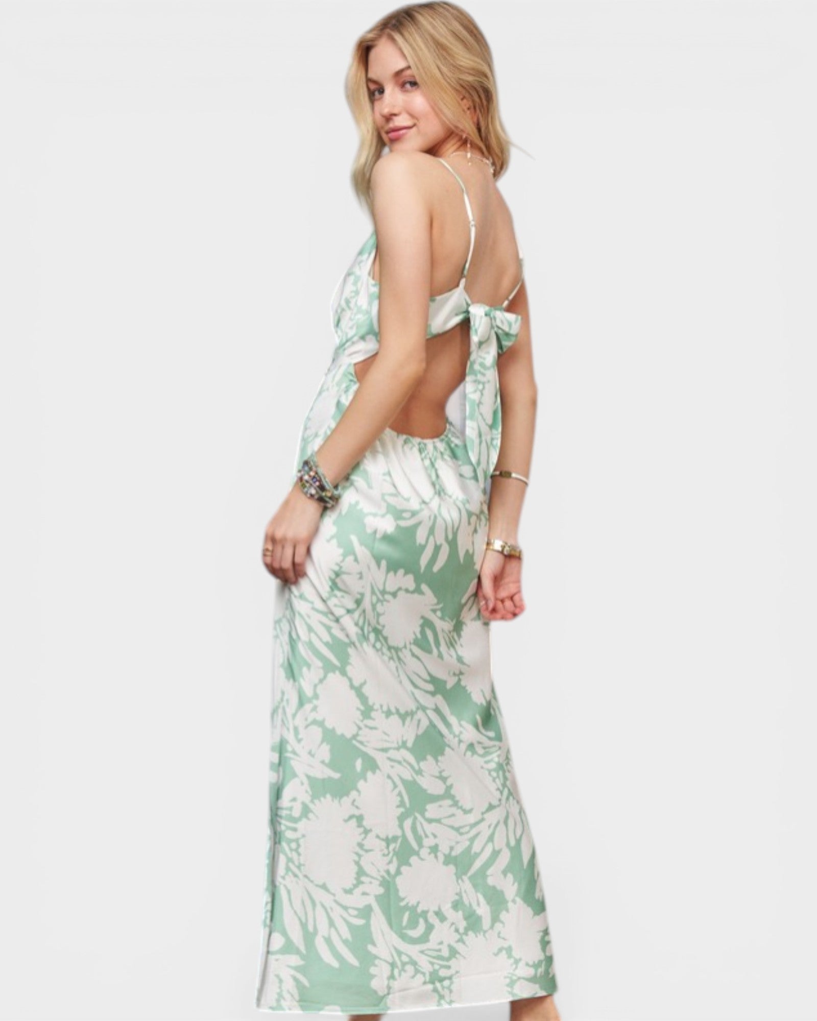 Woman wearing a green and white floral dress on a white background