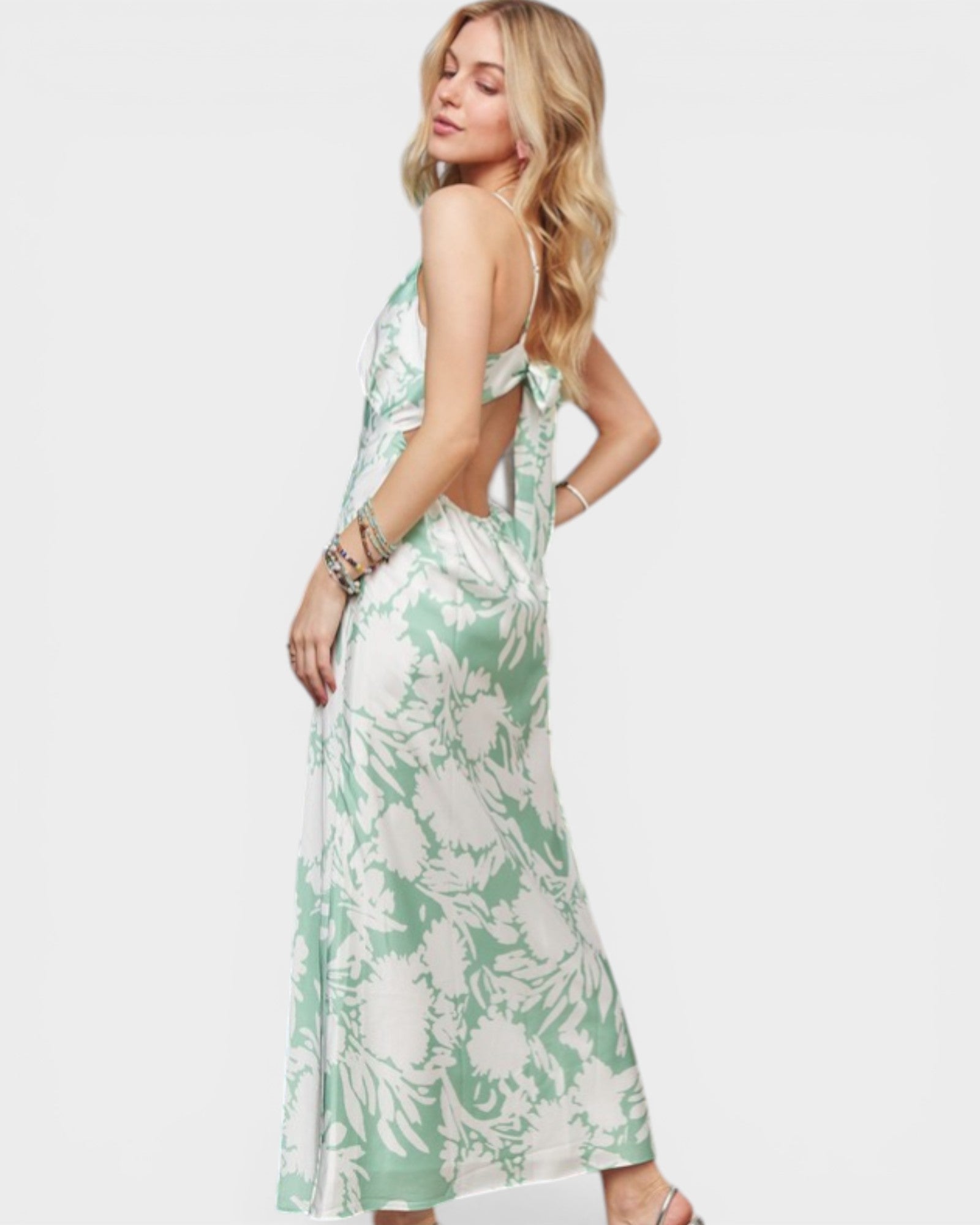 Woman wearing a green and white floral dress on a white background