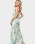 Woman wearing a green and white floral dress on a white background