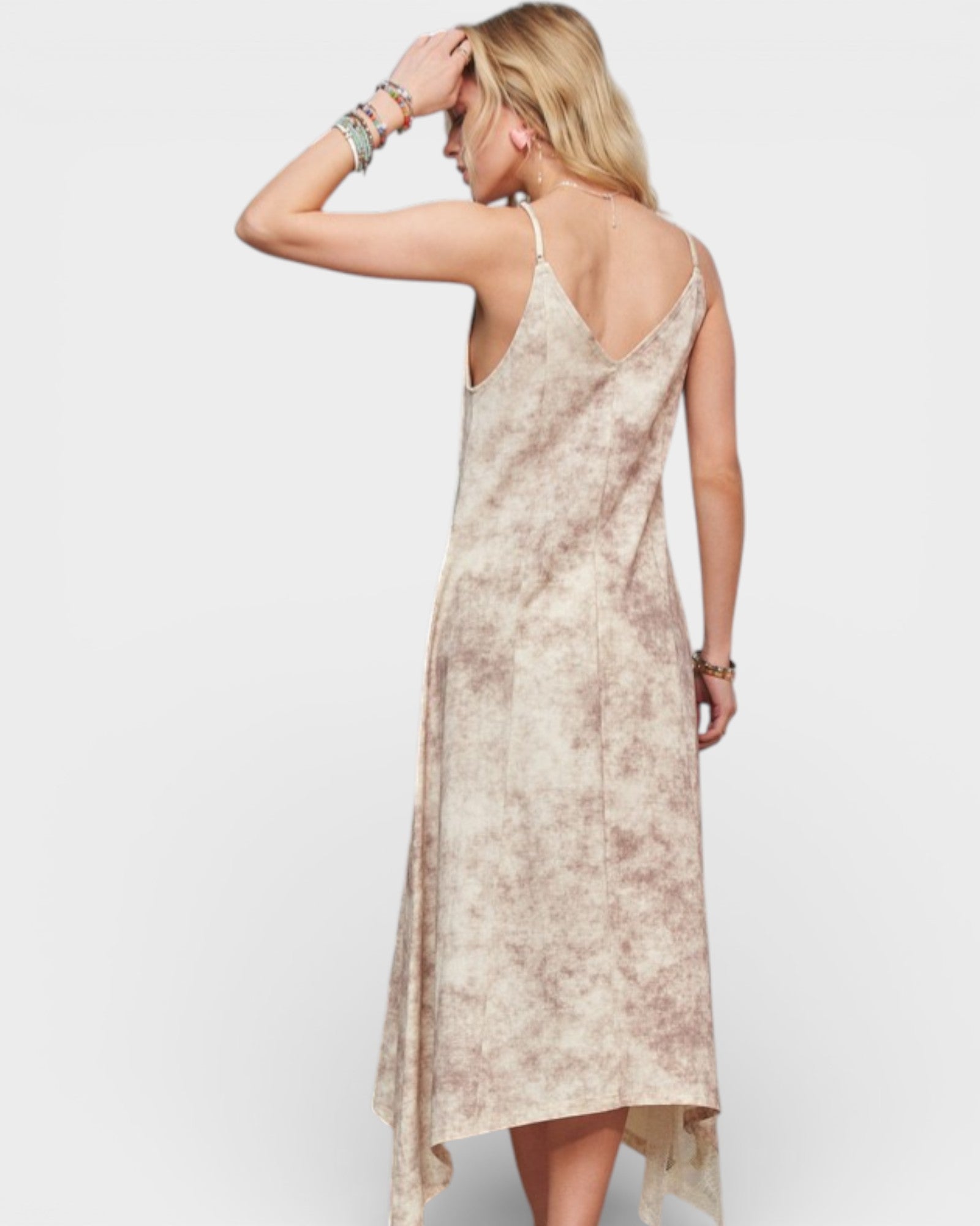 Woman wearing a beige slip dress against a white background