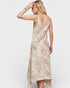 Woman wearing a beige slip dress against a white background