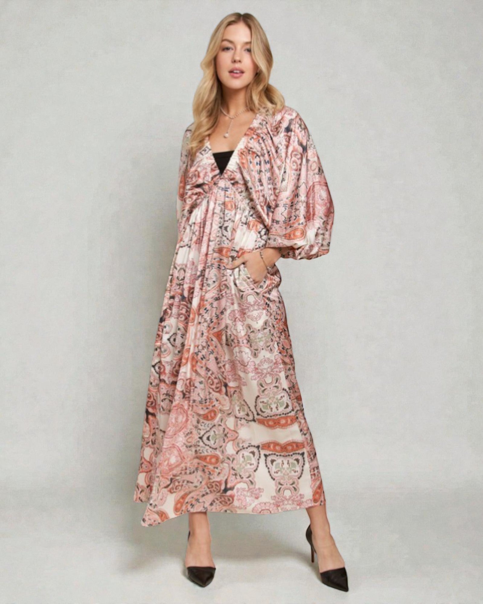 Woman wearing a floral patterned dress on a plain background