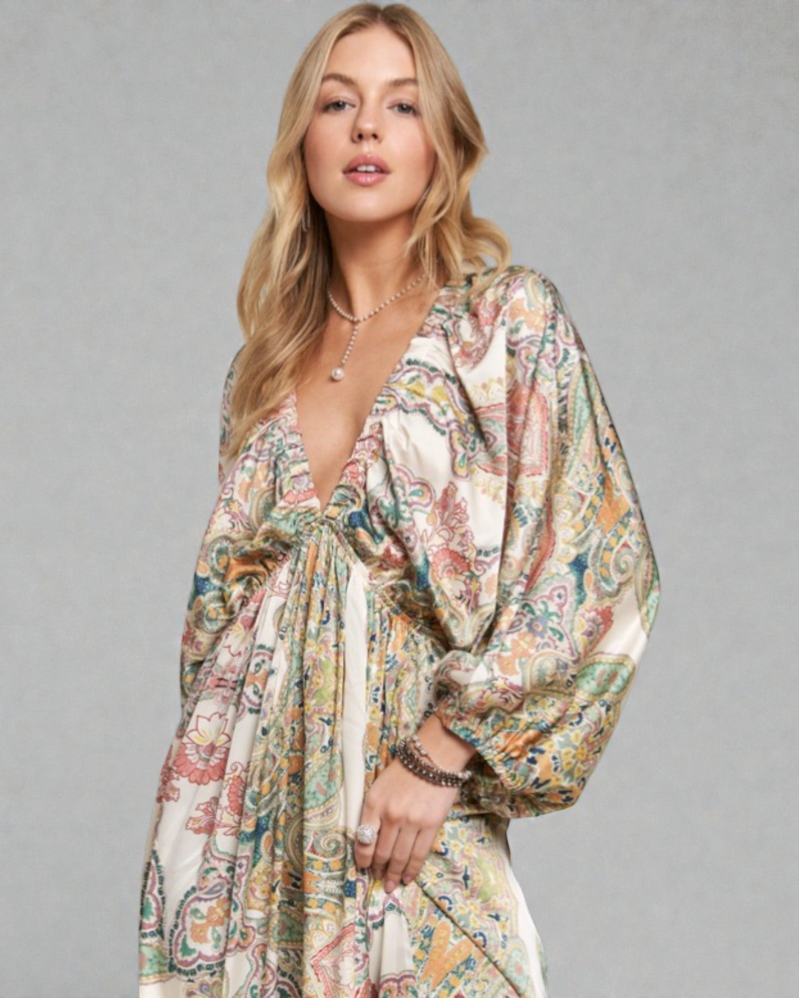 Woman wearing a floral dress against a gray background