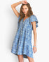 A woman modeling a short-sleeve blue and white floral print dress with a V-neckline and ruffled sleeves, posed against a clean white studio background.