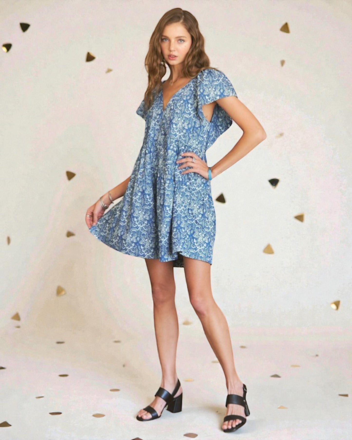 Woman wearing a blue floral dress against a light background