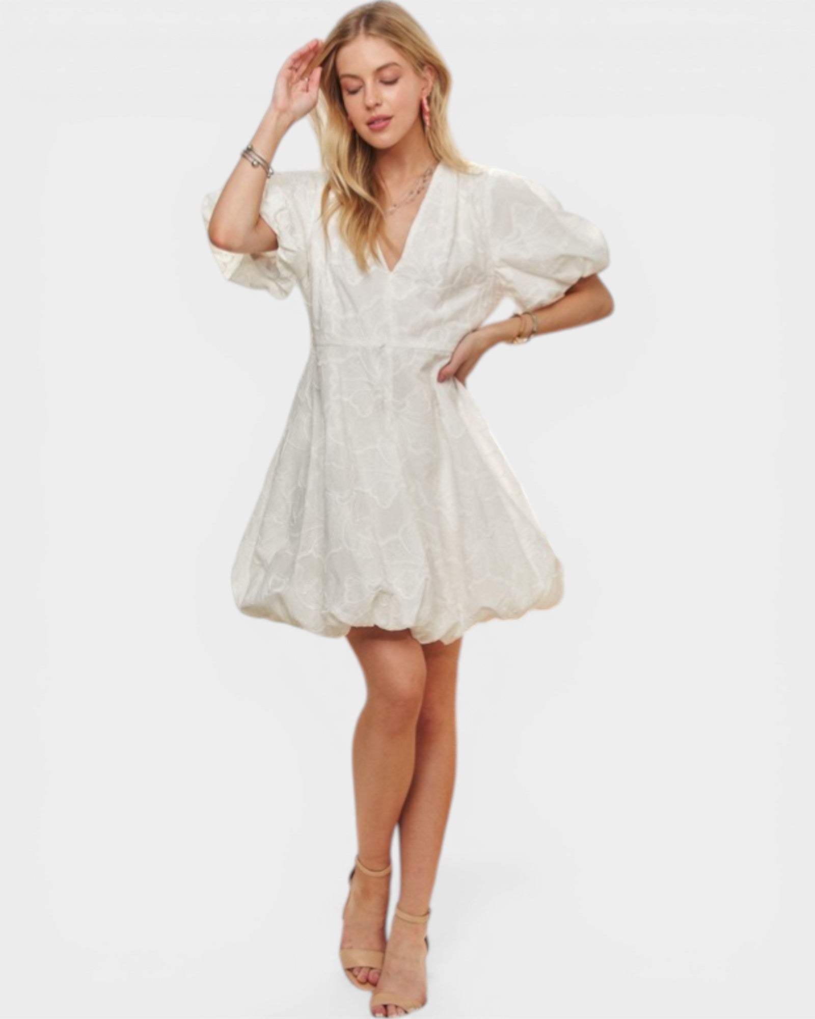 Woman wearing a white dress with puff sleeves on a white background