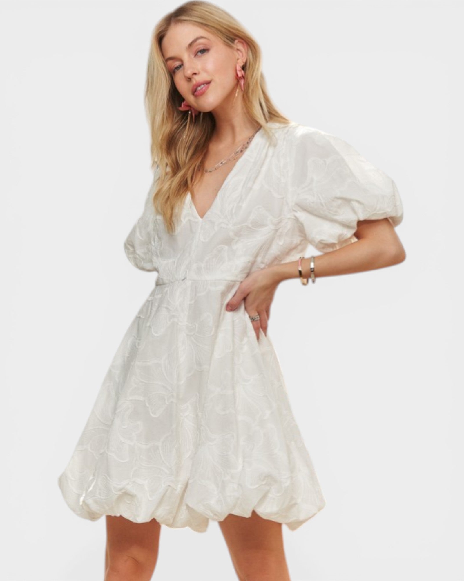 Woman wearing a white dress with puff sleeves on a white background