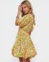 Woman wearing a colorful floral dress on a white background